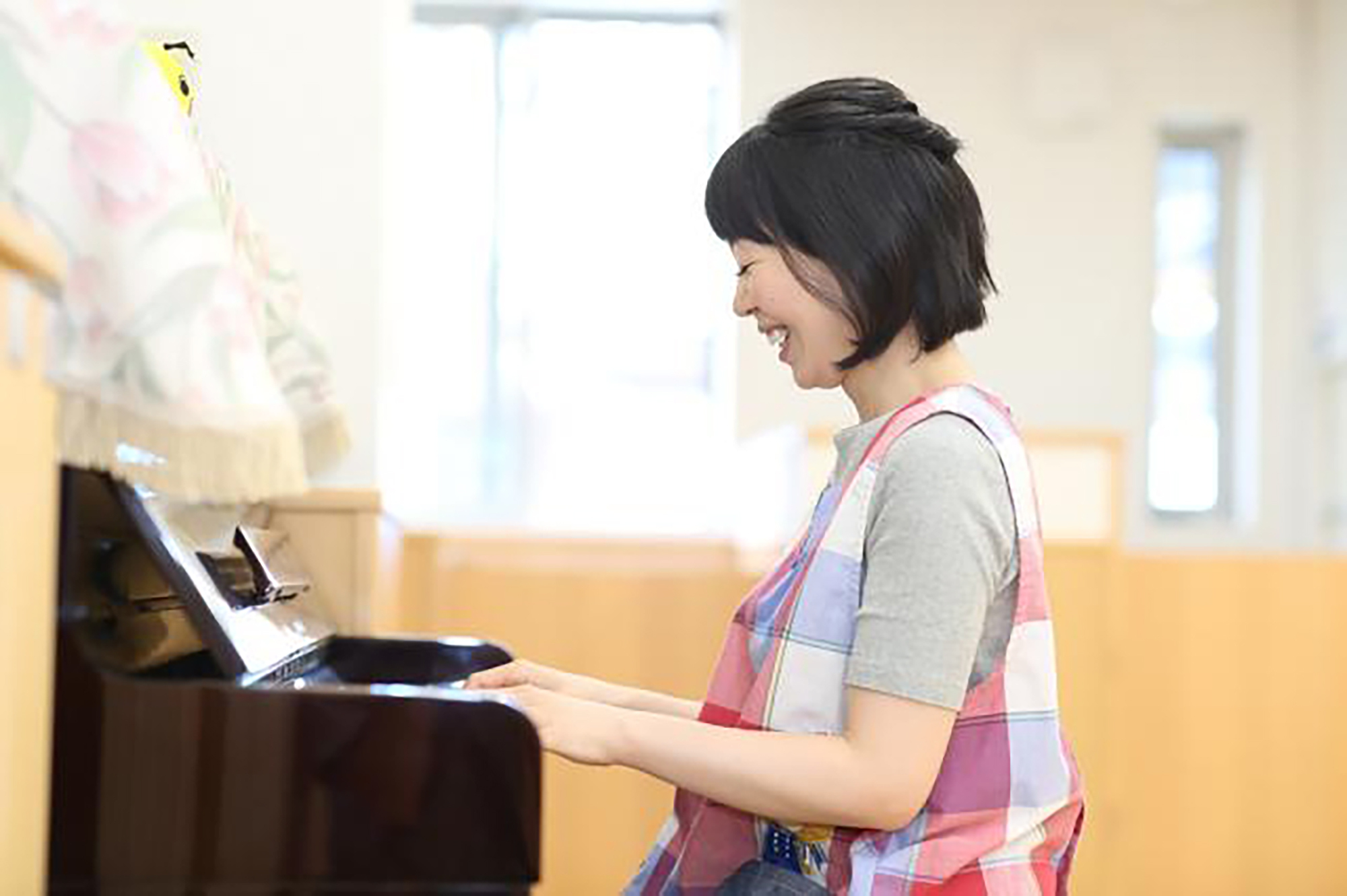 写真：ピアノを弾く保育士